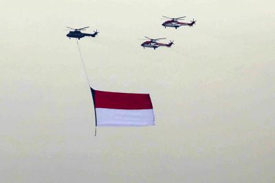Sejumlah helikopter TNI Angkatan Udara terbang membawa bendera Merah Putih di Jakarta, Jumat (13/8/2021).