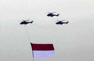 Sejumlah helikopter TNI Angkatan Udara terbang membawa bendera Merah Putih di Jakarta, Jumat (13/8/2021).