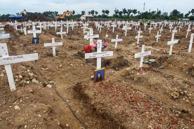 Petugas memindahkan tanah untuk merapihkan makam di Tempat Pemakaman Umum (TPU) Rorotan, Jakarta Utara, Jumat (13/8/2021).