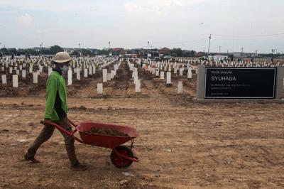 Petugas memindahkan tanah untuk merapihkan makam di Tempat Pemakaman Umum (TPU) Rorotan, Jakarta Utara, Jumat (13/8/2021).