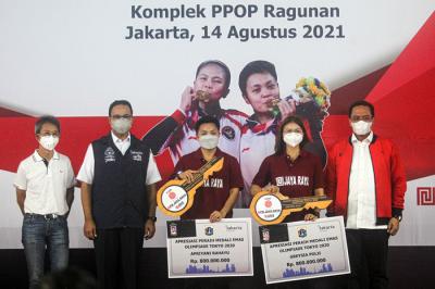 Gubernur DKI Jakarta Anies Baswedan memberikan hadiah apresiasi kepada Greysia Polii/Apriyani Rahayu di Jakarta, Sabtu (14/8/2021).
