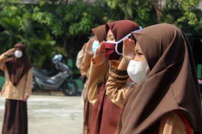 Siswa-siswi SMP dan SMK Syahid melakukan upacara peringatan Hari Pramuka ke-60 di kawasan Cilincing, Jakarta Utara, Sabtu (14/8/2021).