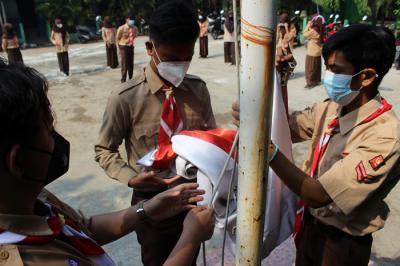 Siswa-siswi SMP dan SMK Syahid melakukan upacara peringatan Hari Pramuka ke-60 di kawasan Cilincing, Jakarta Utara, Sabtu (14/8/2021).