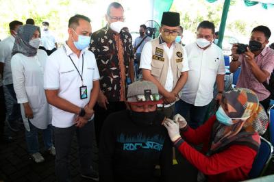 Warga mendapatkan suntikan vaksin Covid-19 ketika mengikuti vaksinasi massal yang dihelat BP Jamsostek di Madura, Jawa Timur, Sabtu (14/8/2021).
