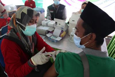 Warga mendapatkan suntikan vaksin Covid-19 ketika mengikuti vaksinasi massal yang dihelat BP Jamsostek di Madura, Jawa Timur, Sabtu (14/8/2021).