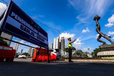Petugas kepolisian saat mengatur kendaraan yang melintas di Jalan Jenderal Sudirman, Jakarta Pusat, Minggu (15/8/2021).