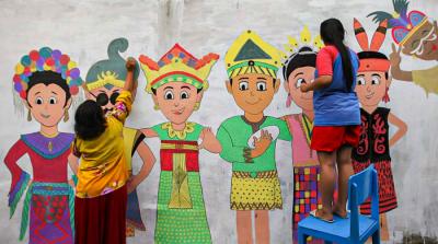 Winy bersama keluarganya saat membuat mural bertema keberagaman budaya Indonesia di Jalan Annur, Lubang Buaya, Jakarta Timur, Minggu (15/8/2021).
