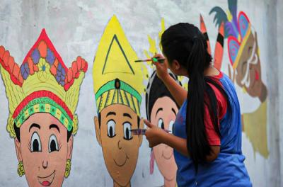 Winy bersama keluarganya saat membuat mural bertema keberagaman budaya Indonesia di Jalan Annur, Lubang Buaya, Jakarta Timur, Minggu (15/8/2021).