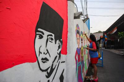 Winy bersama keluarganya saat membuat mural bertema keberagaman budaya Indonesia di Jalan Annur, Lubang Buaya, Jakarta Timur, Minggu (15/8/2021).