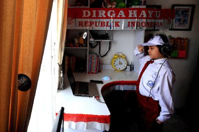 Pelajar SD saat mengikuti lomba makan kerupuk secara online dalam rangka memeriahkan HUT ke-76 RI di kawasan Graha Raya, Tangerang Selatan, Senin (16/8/2021).
