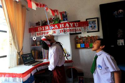 Pelajar SD saat mengikuti lomba makan kerupuk secara online dalam rangka memeriahkan HUT ke-76 RI di kawasan Graha Raya, Tangerang Selatan, Senin (16/8/2021).