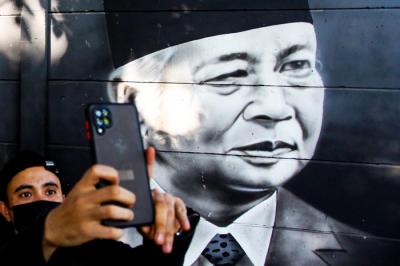 Warga saat melintasi mural para presiden dan pahlwan republik Indonesia di kawasan Cipondoh, Kota Tangerang, Senin (16/8/2021).