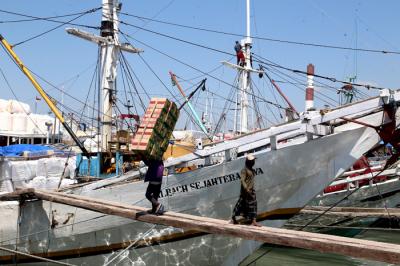 Kuli angkut melakukan bongkar muat di Pelabuhan Gresik, Jawa Timur, Senin (16/8/2021).