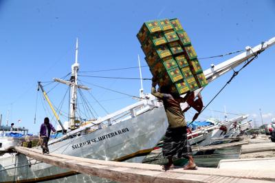 Kuli angkut melakukan bongkar muat di Pelabuhan Gresik, Jawa Timur, Senin (16/8/2021).