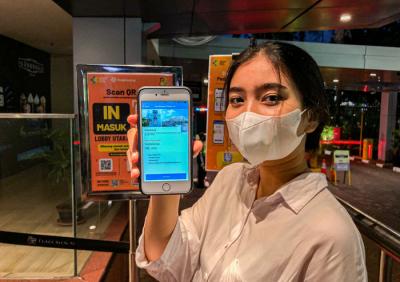 Pengunjung saat melakukan Scan Barcode melalui aplikasi PeduliLindungi sebagai syarat wajib masuk di Plaza Blok M, Jakarta, Senin (16/8/2021).