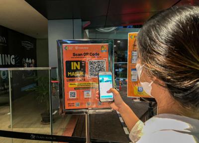 Pengunjung saat melakukan Scan Barcode melalui aplikasi PeduliLindungi sebagai syarat wajib masuk di Plaza Blok M, Jakarta, Senin (16/8/2021).