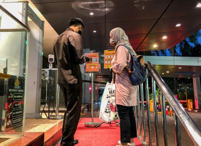 Pengunjung saat melakukan Scan Barcode melalui aplikasi PeduliLindungi sebagai syarat wajib masuk di Plaza Blok M, Jakarta, Senin (16/8/2021).