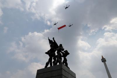 Pesawat tempur Angkatan Udara dan Helikopter Angkatan Darat membawa bendera merah putih di kawasan Monumen Nasional (Monas), Jakarta, Selasa (17/8/2021).