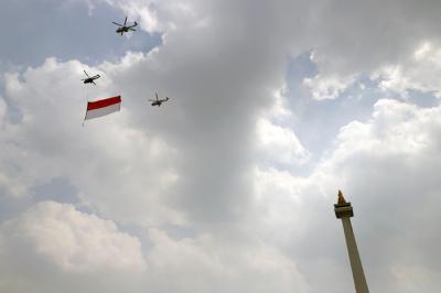 Pesawat tempur Angkatan Udara dan Helikopter Angkatan Darat membawa bendera merah putih di kawasan Monumen Nasional (Monas), Jakarta, Selasa (17/8/2021).