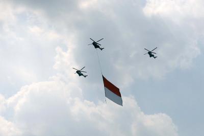 Pesawat tempur Angkatan Udara dan Helikopter Angkatan Darat membawa bendera merah putih di kawasan Monumen Nasional (Monas), Jakarta, Selasa (17/8/2021).