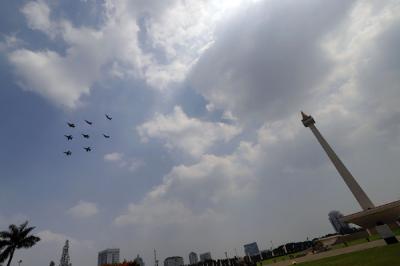 Pesawat tempur Angkatan Udara dan Helikopter Angkatan Darat membawa bendera merah putih di kawasan Monumen Nasional (Monas), Jakarta, Selasa (17/8/2021).