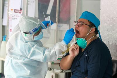 Petugas melakukan swab PCR kepada warga secara drive thru di GSI Lab, Jakarta Selatan, Selasa (17/8/2021).
