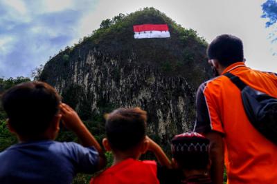 Prosesi pengibaran bendera merah putih di tebing karts Leang Leang, Kabupaten Maros, Selasa (17/8/2021).