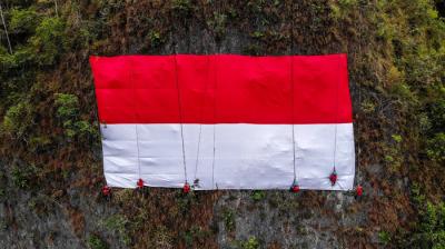 Prosesi pengibaran bendera merah putih di tebing karts Leang Leang, Kabupaten Maros, Selasa (17/8/2021).