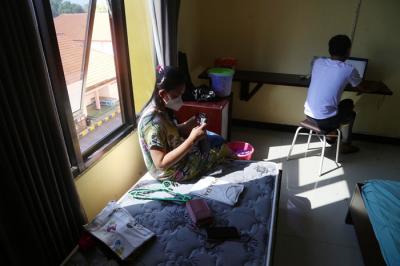 Pasien Covid-19 beraktifitas didalam kamar ketika menjalani isolasi di gedung isolasi Hotel Asrama Haji (HAH) Surabaya, Jawa Timur, Selasa (17/8/2021).
