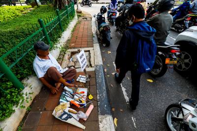 Seorang bapak berprofesi sebagai buruh tukang bangunan menunggu seseorang untuk mengajaknya bekerja di Kawasan Jakarta Pusat, Kamis (19/8/2021).