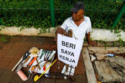 Seorang bapak berprofesi sebagai buruh tukang bangunan menunggu seseorang untuk mengajaknya bekerja di Kawasan Jakarta Pusat, Kamis (19/8/2021).