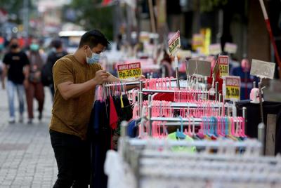 Calon pembeli melihat-lihat baju di salah satu pertokoan di kawasan Pasar Baru, Jakarta, Kamis (19/8/2021).