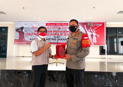 Kapolres Metro Jakpus Kombes Hengki Haryadi memberikan piagam penghargaan kepada relawan Vaksinasi Merdeka di Polres Metro Jakarta Pusat, Jumat (20/8/2021).