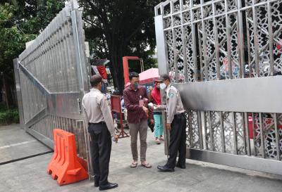 Petugas keamanan mengecek suhu badan warga yang akan menunaikan shalat Jumat di Masjid Istiqlal, Jakarta, Jumat (20/8/2021).