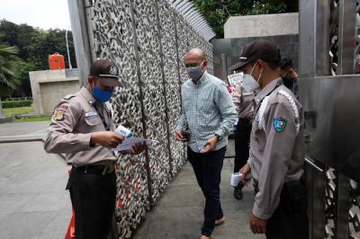 Petugas keamanan mengecek suhu badan warga yang akan menunaikan shalat Jumat di Masjid Istiqlal, Jakarta, Jumat (20/8/2021).