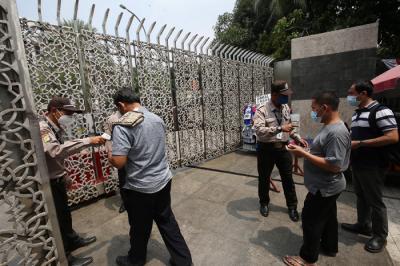 Petugas keamanan mengecek suhu badan warga yang akan menunaikan shalat Jumat di Masjid Istiqlal, Jakarta, Jumat (20/8/2021).