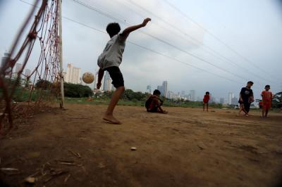 Sejumlah anak bermain sepak bola di bantaran sungai Kanal Banjir Barat, Sabtu (21/8/2021).