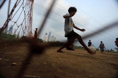 Sejumlah anak bermain sepak bola di bantaran sungai Kanal Banjir Barat, Sabtu (21/8/2021).