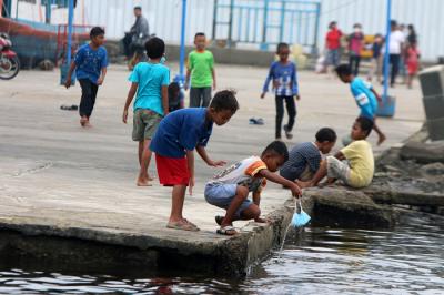 Warga dan anak-anak bermain di kawasan Pelabuhan Kaliadem, Muara Angke, Jakarta, Sabtu (21/8/2021).