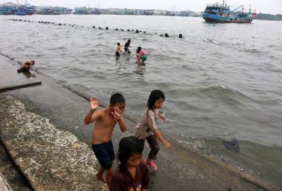 Warga dan anak-anak bermain di kawasan Pelabuhan Kaliadem, Muara Angke, Jakarta, Sabtu (21/8/2021).