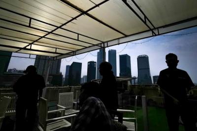 Pengunjung saat menikmati suasana di sebuah resto hotel dengan pemandangan gedung-gedung bertingkat di Jakarta Selatan, Minggu (22/8/2021).