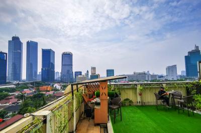 Pengunjung saat menikmati suasana di sebuah resto hotel dengan pemandangan gedung-gedung bertingkat di Jakarta Selatan, Minggu (22/8/2021).