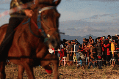Sejumlah warga menyaksikan pacuan kuda tradisional di Kecamatan Simbang, Desa Tanete, Kabupaten Maros, Rabu (25/8/2021).