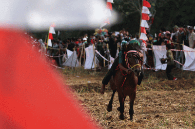 Sejumlah warga menyaksikan pacuan kuda tradisional di Kecamatan Simbang, Desa Tanete, Kabupaten Maros, Rabu (25/8/2021).