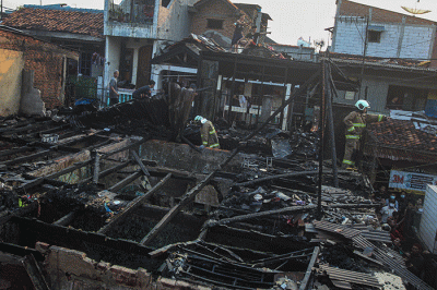 Warga dan petugas pemadam kebakaran saat melakukan pendinginan di lokasi kebakaran di Kampung Pulo, Kampung Melayu, Jatinegara, Jakarta Timur, Rabu (25/8/2021).