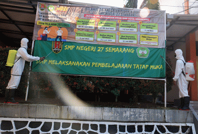 Sejumlah personel Kompi 1 Batalyon A Pelopor Brimob Srondol Semarang melakukan penyemprotan disinfektan di SMP Negeri 27, Semarang, Kamis (26/8/2021).