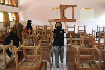Sejumlah personel Kompi 1 Batalyon A Pelopor Brimob Srondol Semarang melakukan penyemprotan disinfektan di SMP Negeri 27, Semarang, Kamis (26/8/2021).