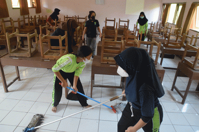 Sejumlah personel Kompi 1 Batalyon A Pelopor Brimob Srondol Semarang melakukan penyemprotan disinfektan di SMP Negeri 27, Semarang, Kamis (26/8/2021).