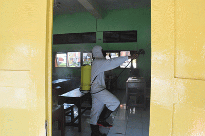 Sejumlah personel Kompi 1 Batalyon A Pelopor Brimob Srondol Semarang melakukan penyemprotan disinfektan di SMP Negeri 27, Semarang, Kamis (26/8/2021).