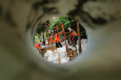 Pekerja sedang menyelesaikan pembuatan drainase vertikal atau sumur resapan di trotoar jalan Gatot Subroto, Jakarta Selatan, Jumat (27/8/2021).